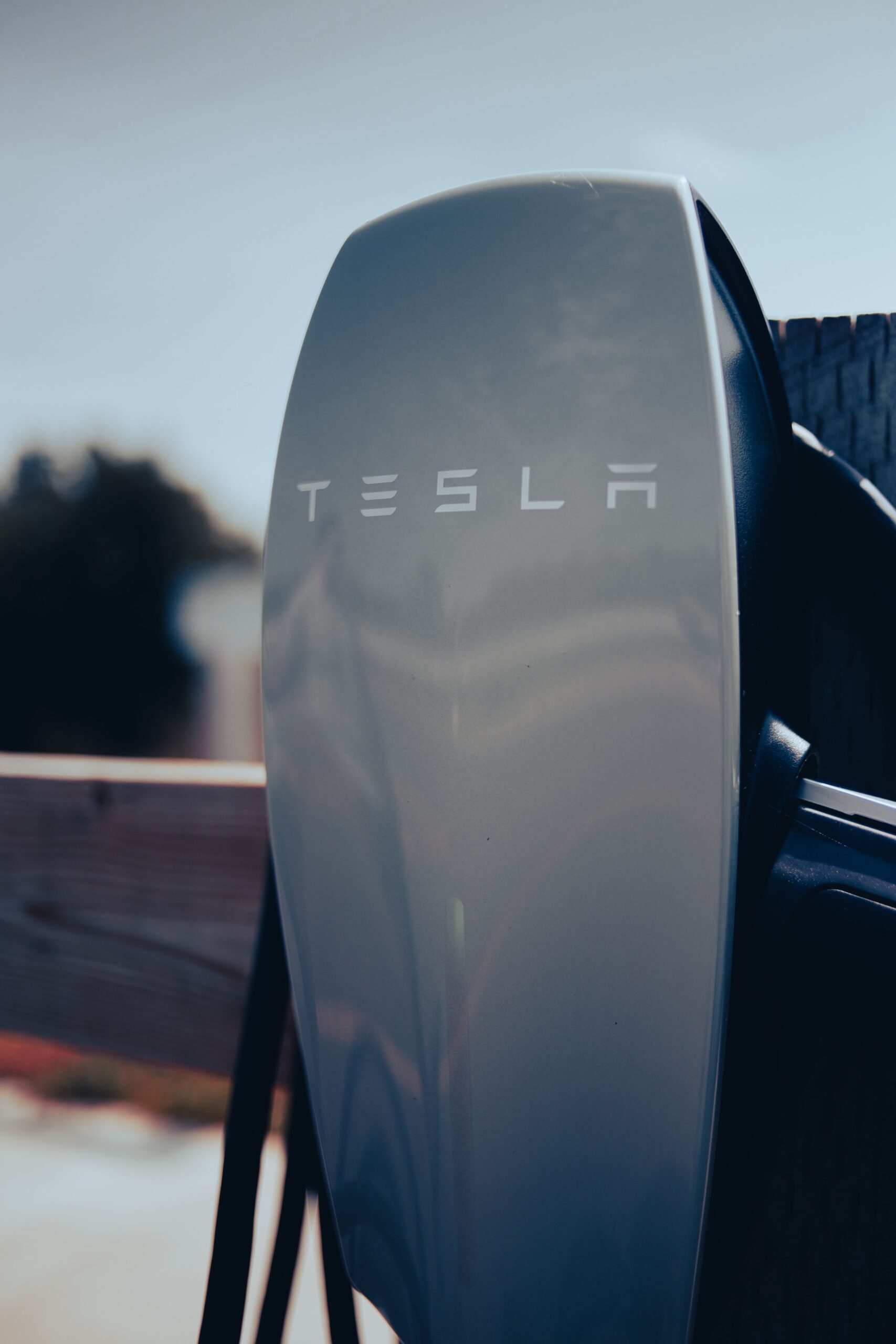 gallery-3 Close-up of a Tesla charging station, showcasing modern electric vehicle technology.